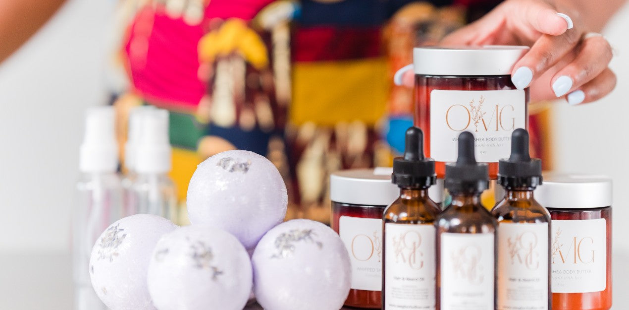 A variety of OMG products including bath bombs, body butter, and beard oil are on display.